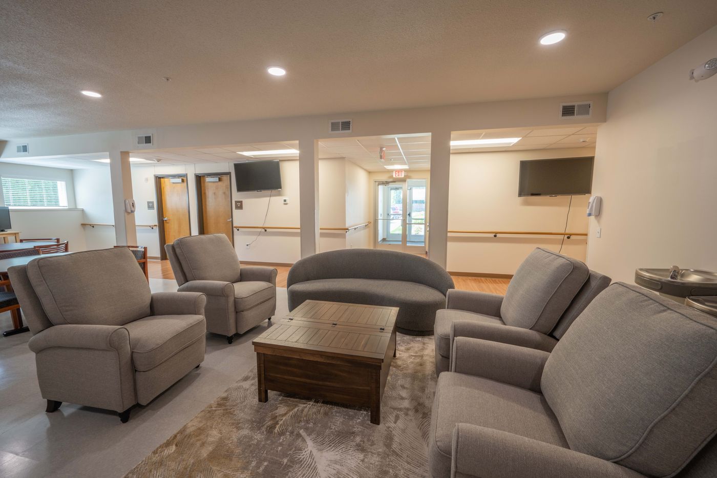 Lounge with recliners and a curved sofa around a coffee table
